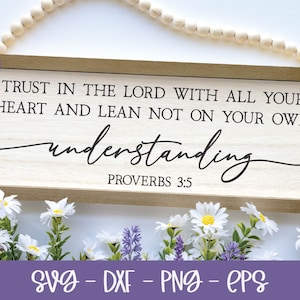 May include: A wooden sign with the text "TRUST IN THE LORD WITH ALL YOUR HEART AND LEAN NOT ON YOUR OWN understanding PROVERBS 3:5" in black lettering. The sign is surrounded by white and purple flowers.