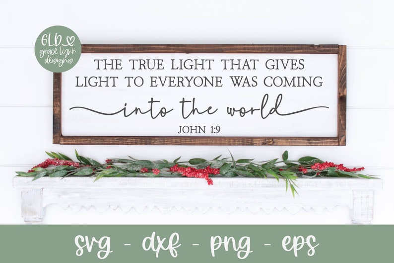 May include: A wooden sign with a white background and brown frame. The sign features the text "THE TRUE LIGHT THAT GIVES LIGHT TO EVERYONE WAS COMING into the world JOHN 1:9".