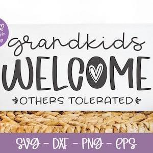 May include: White sign with black text that reads "grandkids welcome others tolerated" with a black heart icon. The sign is sitting on a woven wicker surface.