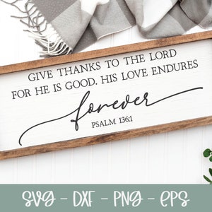 May include: A wooden sign with a white background and brown frame. The sign reads "Give thanks to the Lord for He is good. His love endures forever. Psalm 136:1".