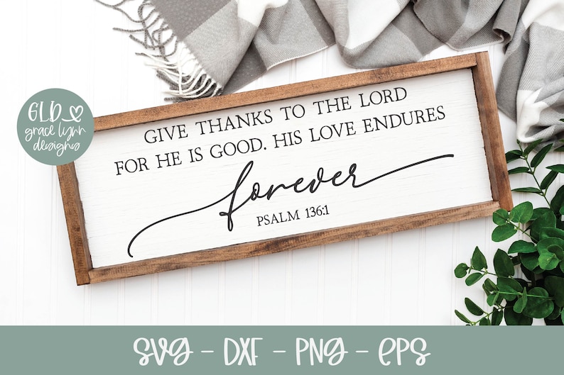 May include: A wooden sign with a white background and brown frame. The sign reads "Give thanks to the Lord for He is good. His love endures forever. Psalm 136:1".