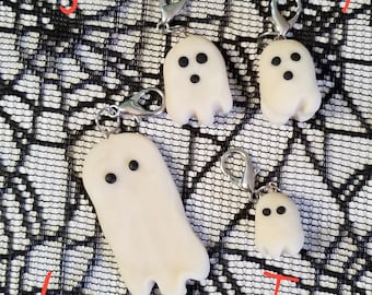 May include: Four white ghost-shaped zipper pulls with black eyes. The zipper pulls are labeled "Jerry", "Sydney", "Jeff", and "Tess".