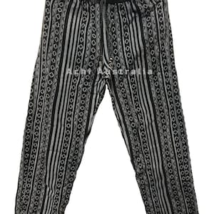 May include: Black and white striped trousers with a geometric pattern. The trousers have an elastic waistband and a drawstring.