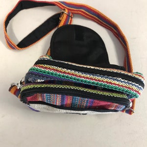 May include: A small, colourful, striped crossbody bag with a black zipper and a black strap. The bag has a small pocket on the back.