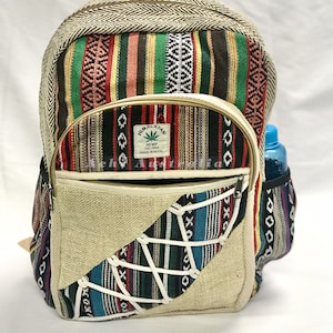 May include: A multi-coloured hemp backpack with a large front pocket and a smaller side pocket. The backpack is made of a variety of fabrics, including hemp, cotton, and jute. The backpack has a zipper closure and a drawstring closure. The backpack is decorated with a variety of patterns, including stripes, geometric patterns, and floral patterns. The backpack has a label that says "Himalayan Hemp THC Free Made in Nepal".