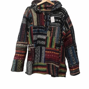 May include: A colourful hooded patchwork sweater with a geometric pattern. The sweater has a drawstring hood and a button closure.