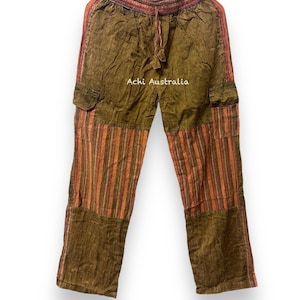 Peut inclure: Pantalon rayé orange rouille avec une taille à cordon et des poches cargo. Le pantalon est fait d'un tissu doux et confortable et a une coupe décontractée.