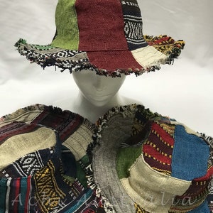 May include: Three colourful patchwork bucket hats with frayed edges. The hats are made of different fabrics with geometric patterns in shades of red, blue, green, brown, and beige.