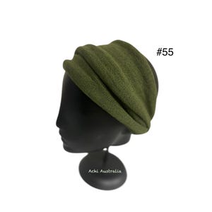 Könnte beinhalten: Ein grünes Stoff Stirnband auf einem schwarzen Mannequin Kopf. Das Stirnband ist gefaltet und hat eine strukturierte Oberfläche. Der Text #55 ist in der oberen rechten Ecke des Bildes sichtbar.