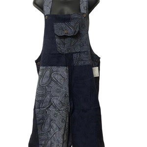 May include: Navy blue overalls with a white and black swirl pattern. The overalls have a large pocket on the front and adjustable straps.