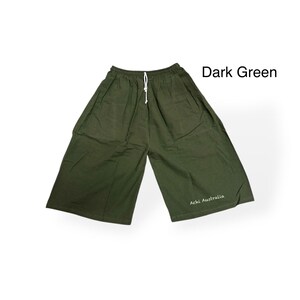 May include: Dark green wide-leg trousers with a white drawstring. The trousers are made of a lightweight fabric and have a relaxed fit. The text "Achi Australia" is printed on the lower right leg.