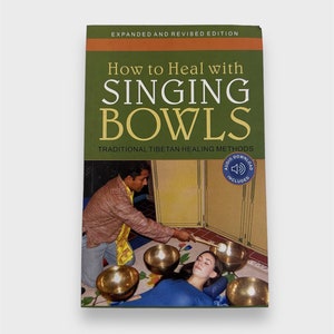 Op de afbeelding: Een boekomslag met een groene achtergrond en de titel "How to Heal with Singing Bowls" in witte tekst. De ondertitel is "Traditional Tibetan Healing Methods". De omslag toont een foto van een persoon die zangkommen gebruikt om een ​​klankhelingssessie uit te voeren op een persoon die ligt.