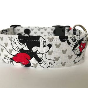 K&ouml;nnte beinhalten: Wei&szlig;er Hundehalsband mit einem schwarzen und roten Mickey Mouse-Druck. Das Halsband hat eine silberne Schnalle.