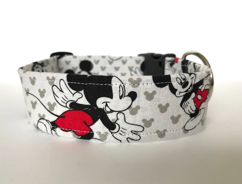 K&ouml;nnte beinhalten: Wei&szlig;er Hundehalsband mit einem schwarzen und roten Mickey Mouse-Druck. Das Halsband hat eine silberne Schnalle.