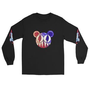 Puede incluir: Camiseta negra de manga larga con un gráfico colorido similar a un oso en la parte delantera. El oso tiene un diseño rojo, blanco y azul. Las mangas tienen un diseño de cohete. Una camiseta gráfica única y llamativa.