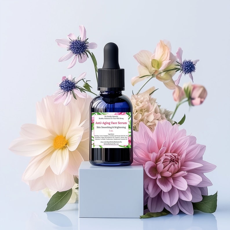 May include: A dark blue glass bottle of Anti-Aging Face Serum with a black dropper, set against a backdrop of pink and white flowers. The label reads "Anti-Aging Face Serum Skin Smoothing & Brightening". The bottle is on a white cube.