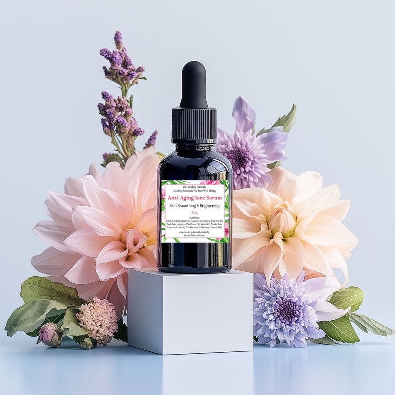 May include: A dark glass bottle of anti-aging face serum with a black dropper, set on a white cube. The label reads "Anti-Aging Face Serum Skin Smoothing & Brightening." The bottle is surrounded by pink, peach, and purple flowers.