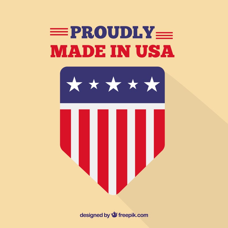 May include: A patriotic design featuring a shield with red and white stripes and a blue top with white stars. The text "PROUDLY MADE IN USA" is displayed above the shield in red and blue.
