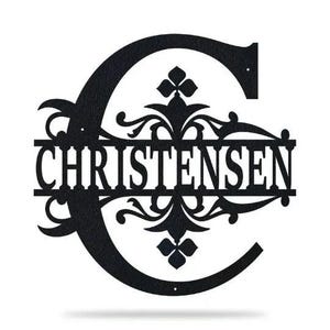 May include: Black metal monogram with the letter C and the last name Christensen. The monogram is decorated with a floral design.