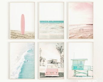 Op de afbeelding: Set van zes printbare wandkunstprints met een roze surfplank, een blauwe oceaan golf, een roze en blauwe strandscene, een blauwe oceaan golf met surfers, een roze busje met surfplanken op het dak en een blauwe reddingspost.