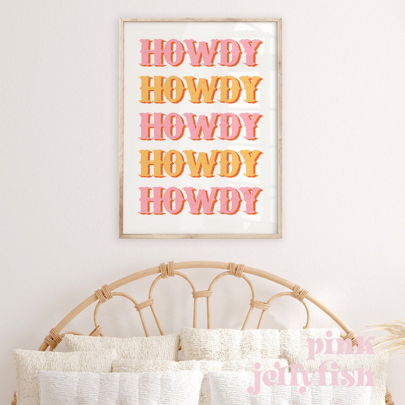 May include: A framed print with the word "HOWDY" repeated five times in a retro font. The word is in pink and orange, with a white background.
