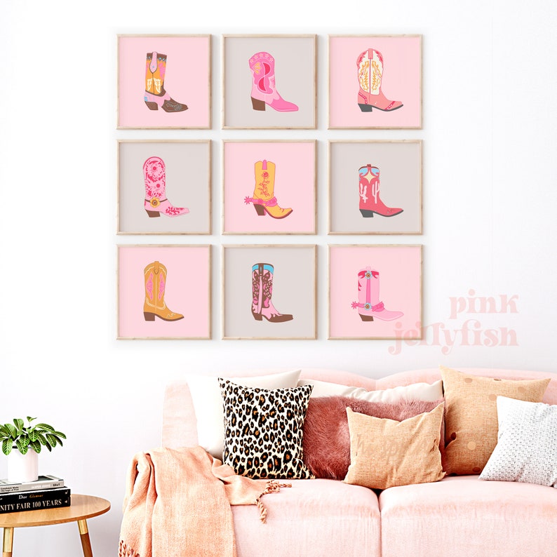 May include: Nine framed prints of pink, yellow, and orange cowboy boots with various designs. The prints are arranged in a grid on a white wall above a pink sofa.