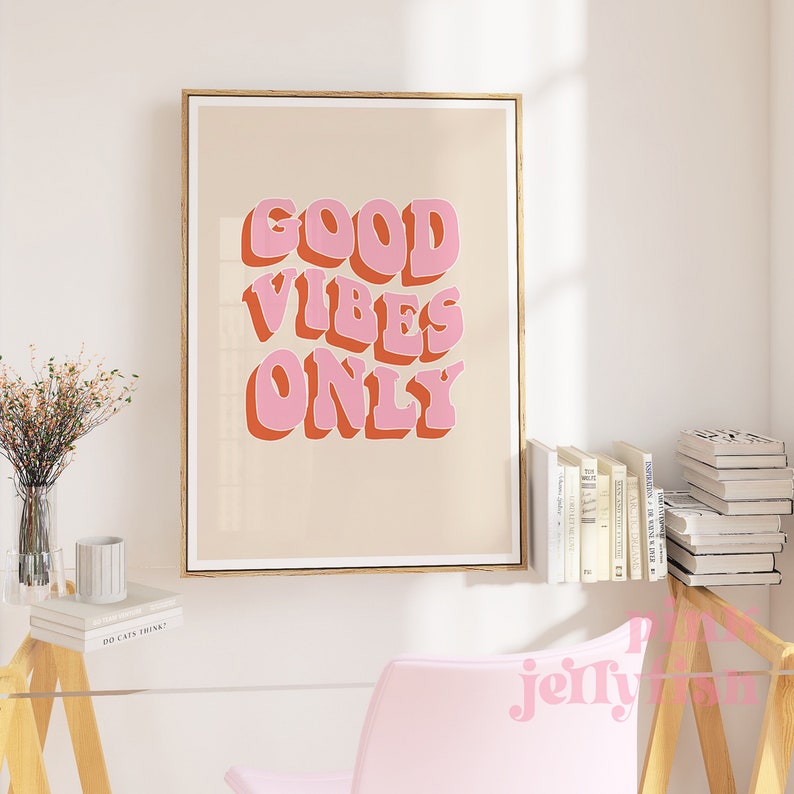 May include: A framed print with a peach background and the text "GOOD VIBES ONLY" in pink and orange letters with a 3D effect.