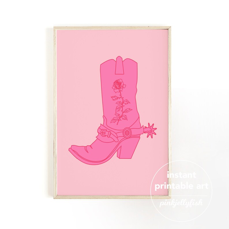 Pode incluir: Uma bota de cowboy rosa com um desenho de rosa e uma esporada. A bota &eacute; delineada em um rosa mais escuro e &eacute; colocada sobre um fundo rosa claro.