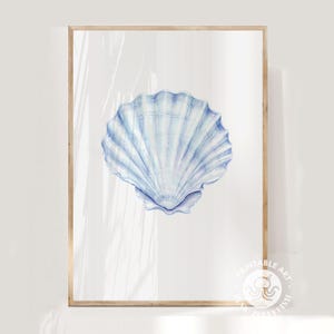 Pode incluir: Uma impressão emoldurada com uma ilustração em aquarela de uma concha azul clara. A concha é detalhada com sombreamento suave e está sobre um fundo branco. A moldura é de cor de madeira clara, adicionando um toque natural à obra.