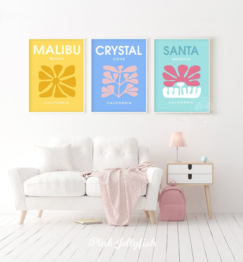 May include: Three minimalist art prints with abstract floral designs in yellow, blue, and turquoise. The prints feature the text "Malibu Beach California", "Crystal Cove California", and "Santa Monica California".