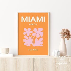 May include: Orange and pink abstract art print with the text "Miami Beach, Florida".