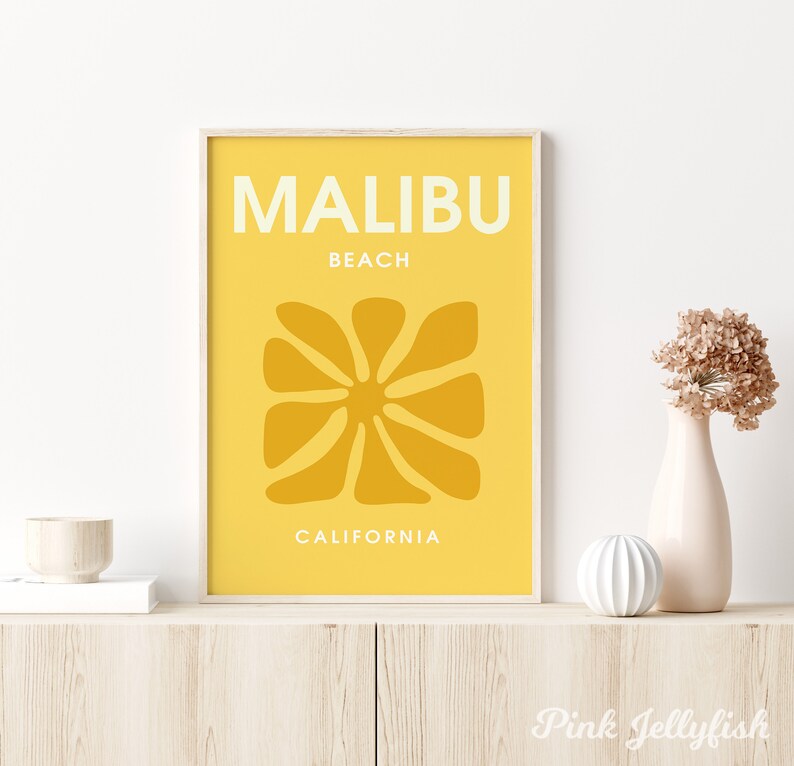 May include: A yellow and white print with the text "MALIBU BEACH CALIFORNIA" and a stylized sun graphic.