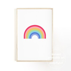 May include: A framed print with a vibrant rainbow design. The rainbow comprises six bands of colour: red, pink, yellow, green, blue, and indigo. The artwork is set against a white background and framed in light wood.