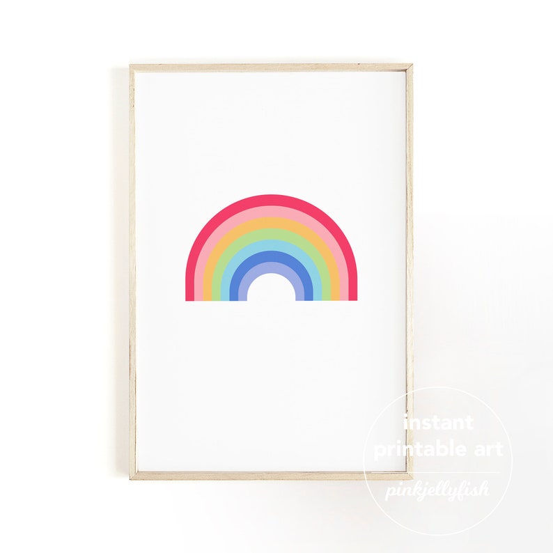 May include: A framed print with a vibrant rainbow design. The rainbow comprises six bands of colour: red, pink, yellow, green, blue, and indigo. The artwork is set against a white background and framed in light wood.