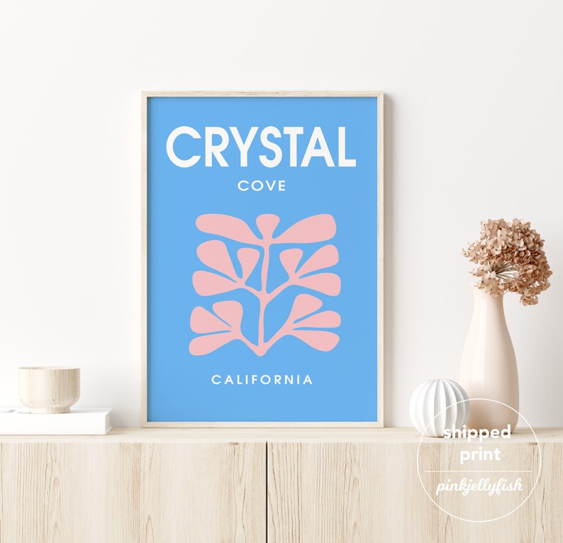 May include: A blue and pink minimalist art print with the text "CRYSTAL COVE CALIFORNIA".