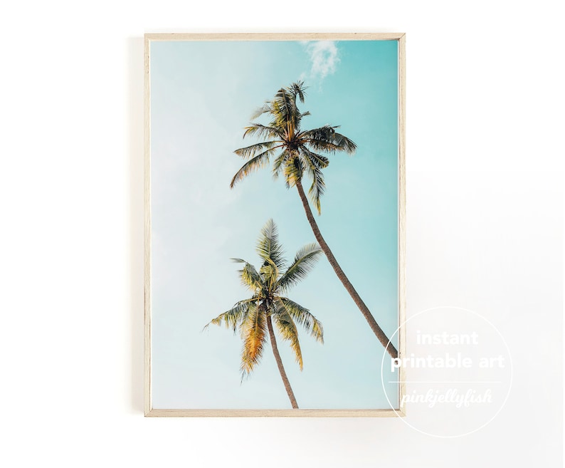 May include: A printable art print featuring two palm trees against a blue sky. The print has a white frame and the text "instant printable art pinkystylish" in the bottom right corner.