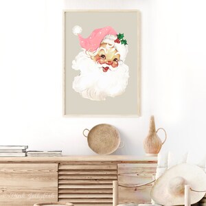 May include: A vintage Christmas illustration of Santa Claus's face with a pink hat and white beard. The background is a light beige colour.