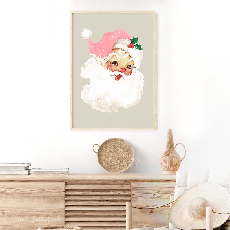 May include: A vintage Christmas illustration of Santa Claus's face with a pink hat and white beard. The background is a light beige colour.