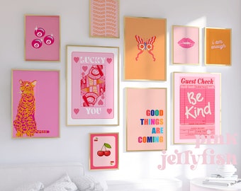 May include: A collection of framed art prints in various sizes and colors. The prints feature a leopard, playing cards, lips, a butterfly, and text that reads "Choose Happy", "Lucky You", "Good Things Are Coming", "Be Kind", and "I am enough".