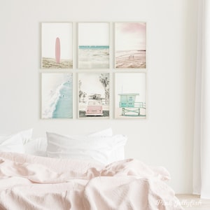 May include: A set of six framed prints featuring beach scenes. The prints include a pink surfboard, a blue ocean with waves, a pink and blue lifeguard stand, a pink van with surfboards on top, and two beach scenes with a pink sky.