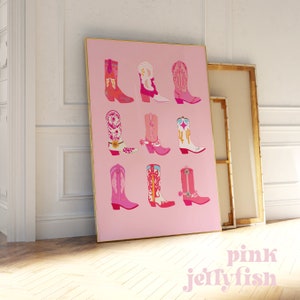 May include: A pink framed print featuring nine colorful cowboy boots in various designs. The boots are in shades of pink, red, orange, and white, with decorative patterns and accents. The text "pink jellyfish" is in the lower right corner.