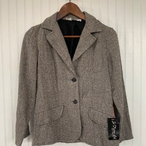 Op de afbeelding: Een bruin en wit herringbone blazer met een zwarte voering en drie zwarte knopen. De blazer heeft een zak aan de linkerkant en een label met de tekst "J'aime Ltd."