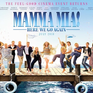 Puede incluir: Un póster de película para la comedia musical Mamma Mia! Aquí Vamos Otra Vez, con el reparto en un muelle de madera. El título de la película está en letras grandes azules con el lema "Aquí Vamos Otra Vez" en letras más pequeñas debajo. La fecha de estreno, "Julio 2018", está impresa debajo del lema.