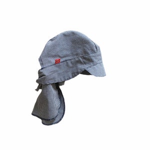 Peut inclure: Un chapeau de chef à carreaux bleus et blancs avec une longue écharpe pour le cou. Le chapeau a un petit logo rouge sur le devant.
