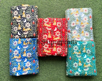 Pode incluir: Seis pacotes de tecido com estampas florais e de coelhos em várias cores: preto, vermelho, azul, azul claro e verde-azulado. Cada pacote apresenta um design repetido de coelhos, flores e luas crescentes. O texto "@thejaipurprints" é visível.