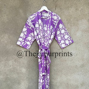 May include: A purple robe with a white floral pattern, hanging on a white hanger. The robe is tied at the waist with a matching belt. The text "@Thejaipurprints" is visible at the bottom.