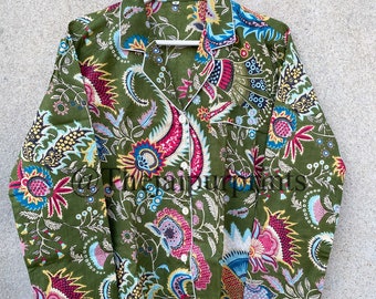 May include: A green long-sleeved shirt with a colourful floral print. The shirt has a button-up collar and a white trim.