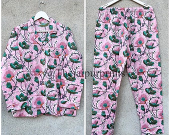 May include: Pink pajama set with a floral print. The top has a button-up front and long sleeves. The pants have an elastic waistband.