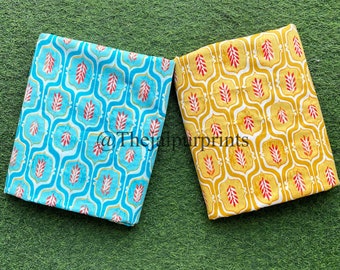 May include: Two folded fabric pieces with repeating patterns. One is turquoise with a white and red leaf design, the other is yellow with a similar pattern. The text "@thejaipurprints" is visible.