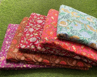 May include: A stack of five fabric panels with floral patterns in various colors, including purple, brown, pink, red, and green. The fabric is folded and stacked on a green surface. The text "@thejaipurpurpl" is visible on the fabric.